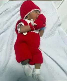 Bebé modelando una pieza tejida por AMV Crochet