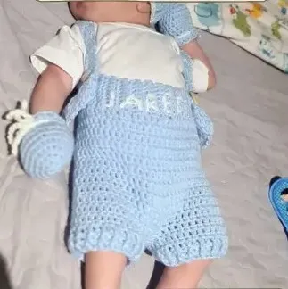 Bebé modelando una pieza tejida por AMV Crochet