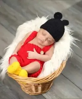 Bebé modelando una pieza tejida por AMV Crochet