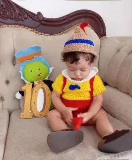 Bebé modelando una pieza tejida por AMV Crochet