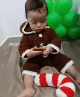 Bebé modelando una pieza tejida por AMV Crochet