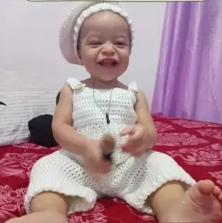 Bebé modelando una pieza tejida por Hilo & Cuna
