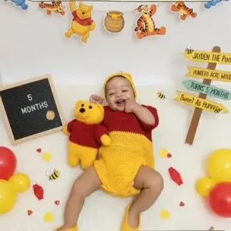 Bebé modelando una pieza tejida por AMV Crochet