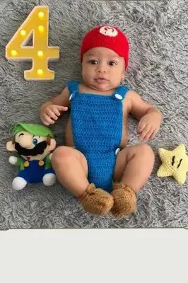 Bebé modelando una pieza tejida por AMV Crochet