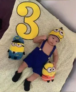 Bebé modelando una pieza tejida por AMV Crochet