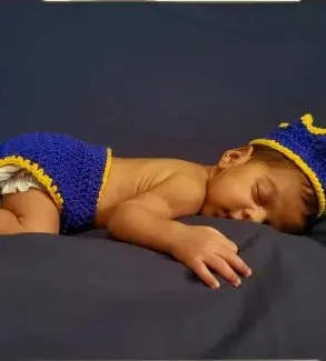 Bebé modelando una pieza tejida por AMV Crochet