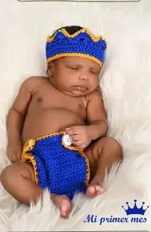 Bebé modelando una pieza tejida por AMV Crochet