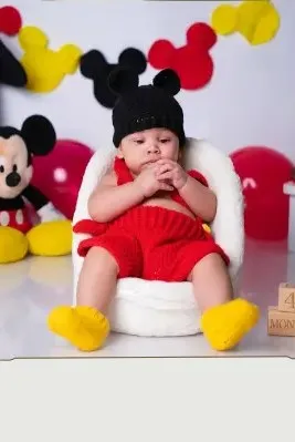 Bebé modelando una pieza tejida por AMV Crochet