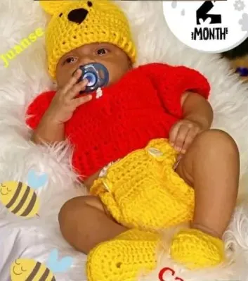 Bebé modelando una pieza tejida por AMV Crochet