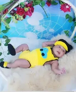 Bebé modelando una pieza tejida por AMV Crochet