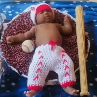 Bebé modelando una pieza tejida por AMV Crochet