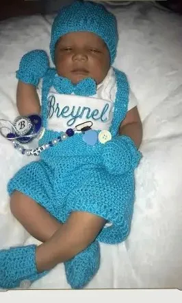 Bebé modelando una pieza tejida por AMV Crochet