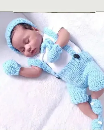 Bebé modelando una pieza tejida por AMV Crochet