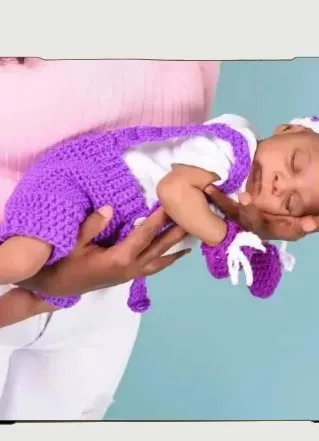 Bebé modelando una pieza tejida por AMV Crochet