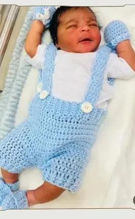 Bebé modelando una pieza tejida por AMV Crochet