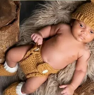 Bebé modelando una pieza tejida por Hilo & Cuna