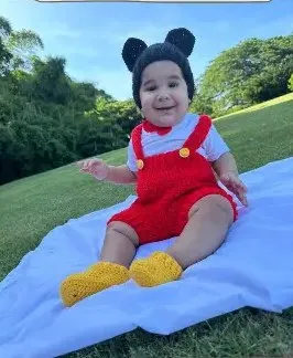 Bebé modelando una pieza tejida por AMV Crochet