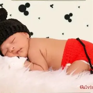 Bebé modelando una pieza tejida por AMV Crochet