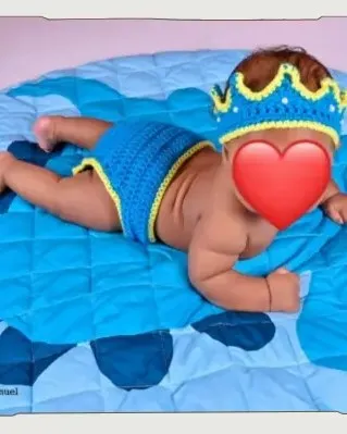 Bebé modelando una pieza tejida por AMV Crochet