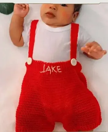 Bebé modelando una pieza tejida por AMV Crochet