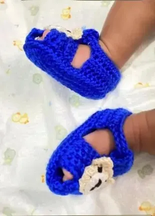 Bebé modelando una pieza tejida por AMV Crochet